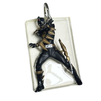 Night Ranger pendant flat front view with black-and-gold hero figure in clear resin