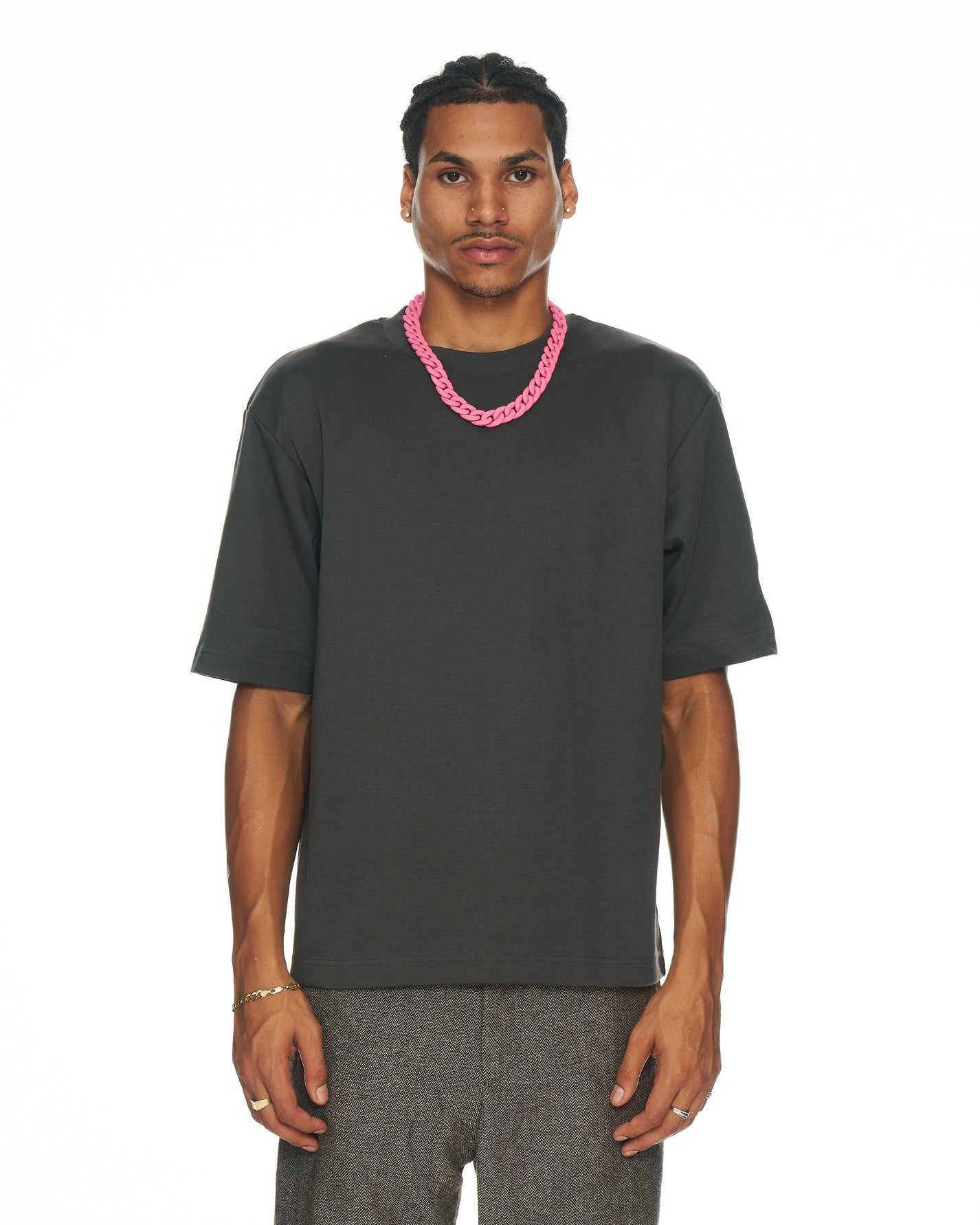 model wearing matte pink Cuban link necklace draped over a black tee